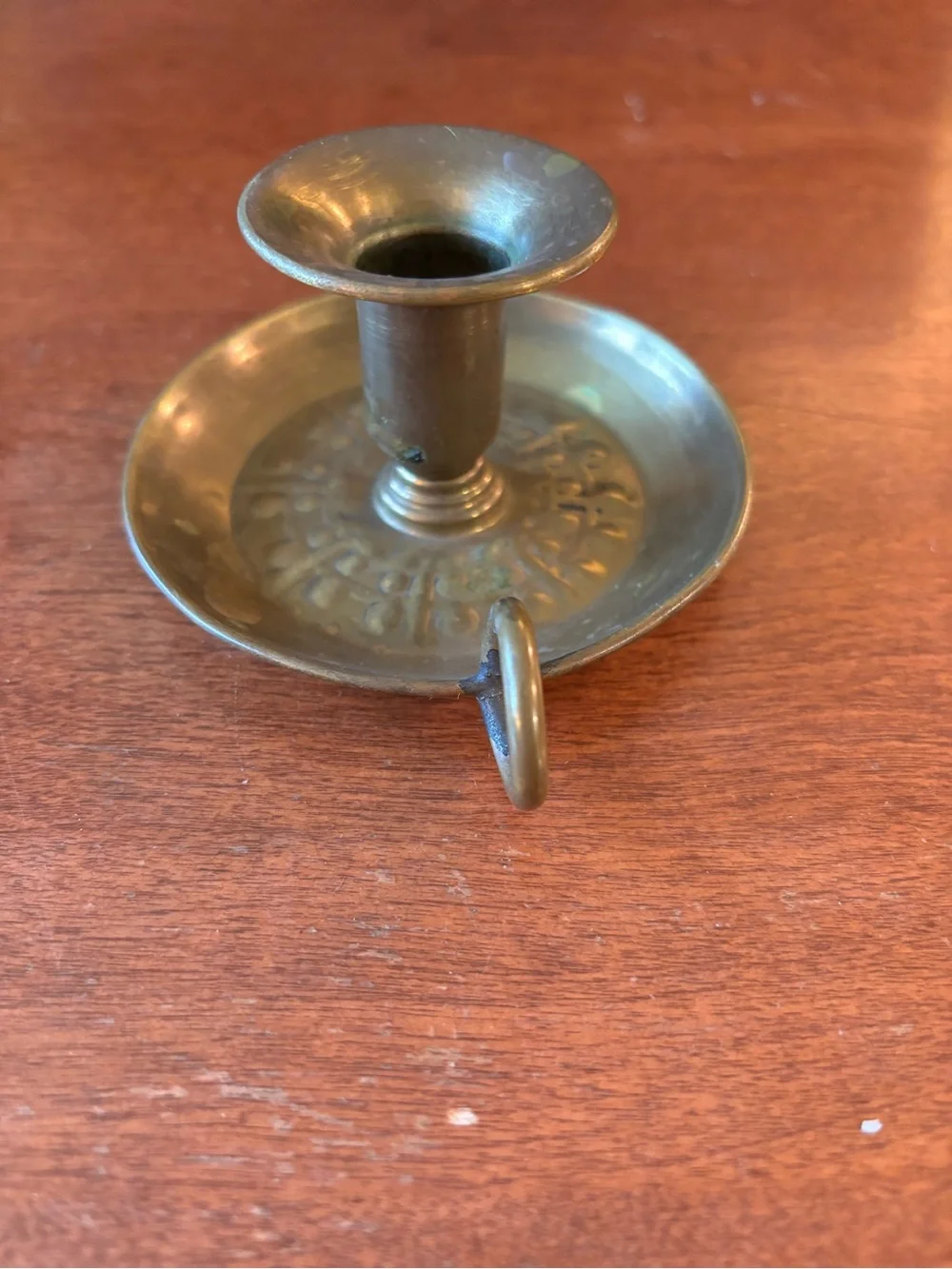 vintage brass chamberstick candle holder with a circular base and a ring handle